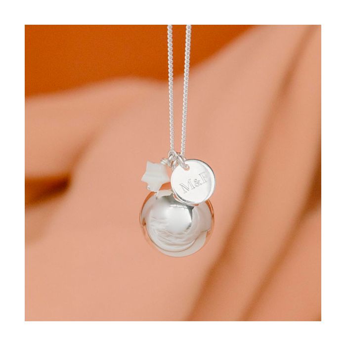 bola de grossesse argent sur lequel on vient graver les initiales des parents sur une medaille